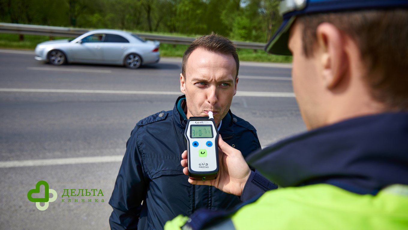 Патрульный проверяет водителя алкотестером
